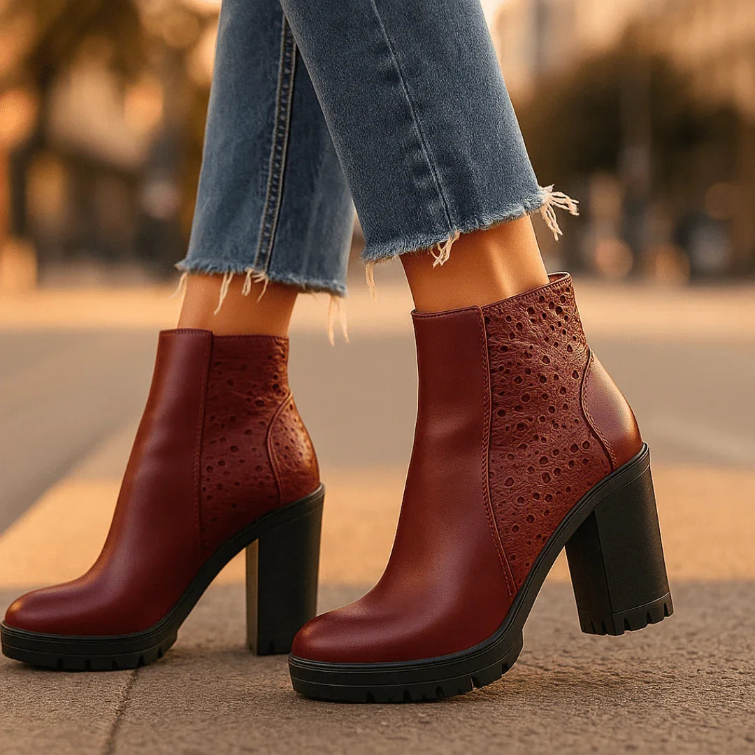 Red high-heeled boots worn with blue jeans on a blurred street background